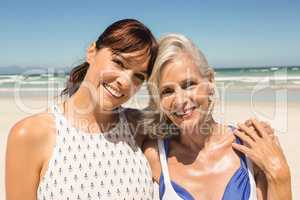 Portrait of smiling mother and daughter standing against clear sky