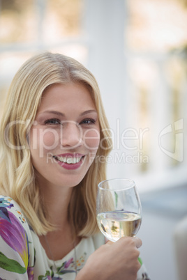 Portrait of smiling woman having wine during lunch