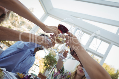 Group of friends toasting glasses of wine during meal