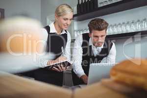 Waiters using laptop at counter