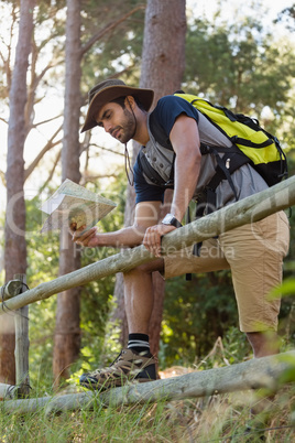 Man reading the map near the wooden fence