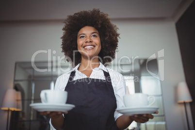 Smiling waitress holding coffee