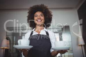 Smiling waitress holding coffee