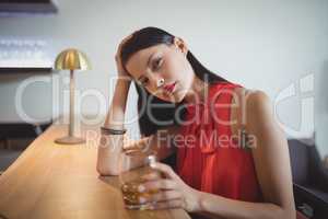 Portrait of tensed woman having a glass of whisky