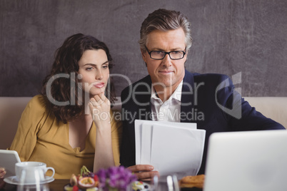 Businessman and colleague working over laptop