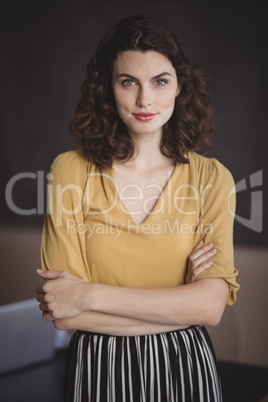 Beautiful woman standing with arms crossed in restaurant