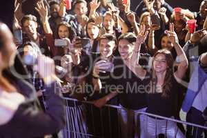 Cheerful young fans photographing performer at nightclub