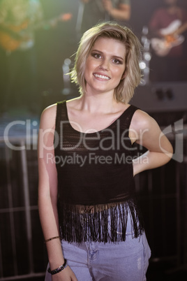 Portrait of smiling woman standing at nightclub