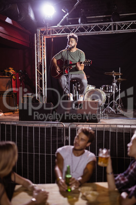 Musician singing with fans sitting at table