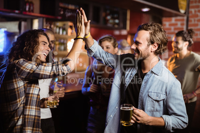 Friends doing high five in club