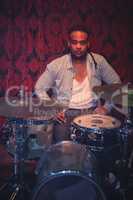 Portrait of musician sitting by drum kit