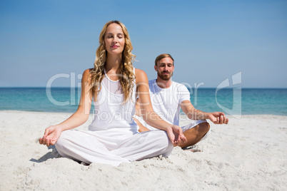 Full length of smiling couple exercising at beach