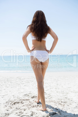 Full length of woman with hand on hip at beach