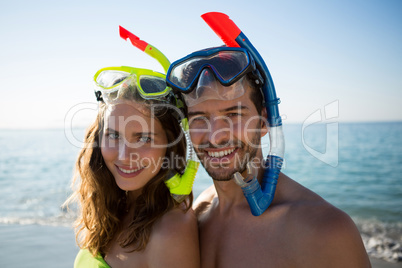 Portrait of happy young couple wearing scuba masks together at beach