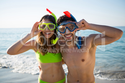 Portrait of happy young couple wearing scuba masks at beach