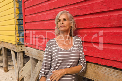 Close up of senior woman looking away while standing by hut