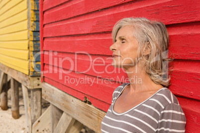 Close up of senior woman with eyes closed standing by wall