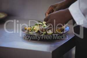 Close-up of chef garnishing meal on counter