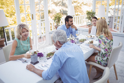 Group of friends interacting with each other while having meal together