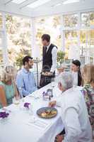 Waiter serving food to customers