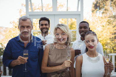 Smiling friends holding champagne glasses in restaurant