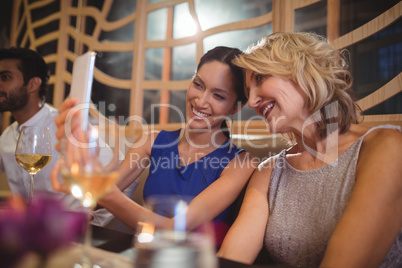 Two beautiful women taking selfie on mobile phone