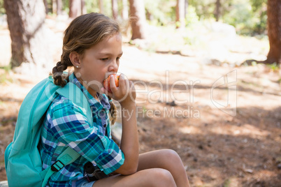 Girl having apple in the forest