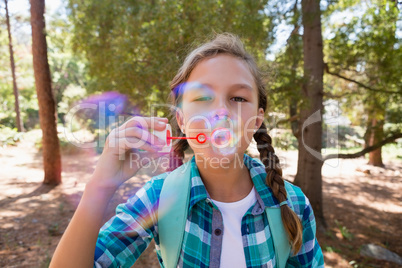 Girl blowing bubbles in the forest