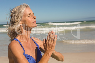 Close up of senior woman meditating at beach