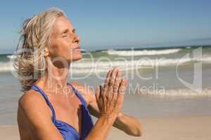 Close up of senior woman meditating at beach