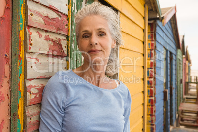 Portrait of confident senior woman standing by wall