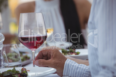 Man holding wine glass while having meal