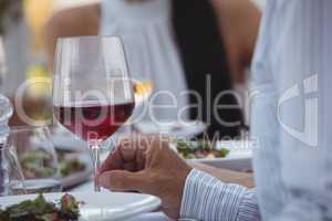 Man holding wine glass while having meal