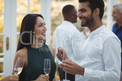 Friends interacting with each other while having champagne