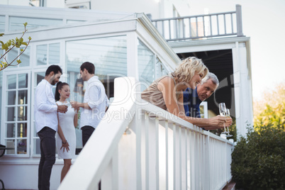 Friends interacting while having champagne in balcony