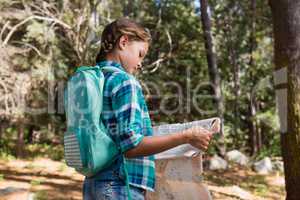 Girl reading the map in the forest