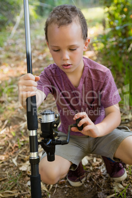 Boy adjusting the fishing rod