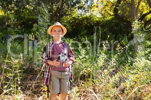 Smiling boy standing in the forest