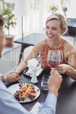 Affectionate couple toasting wine glass while having meal
