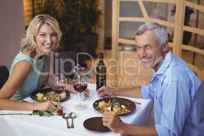 Portrait of mature couple having dinner and red wine