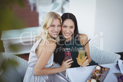 Portrait of smiling womens holding cocktail glass