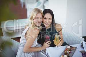 Portrait of smiling womens holding cocktail glass