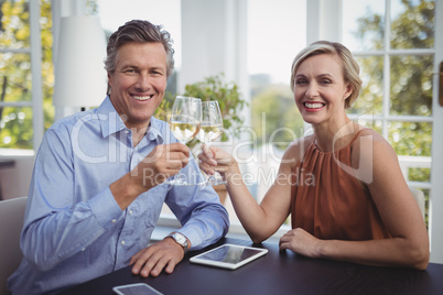 Couple toasting glasses of wine in restaurant