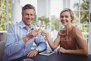 Couple toasting glasses of wine in restaurant