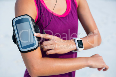 Woman wearing arm band and smart watch at beach