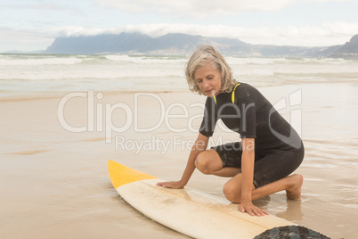 Close up of senior woman preparing for surfboarding