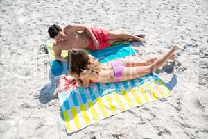 High angle view of couple relaxing on blankets at beach