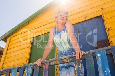 Woman looking away while standing at hut