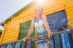 Woman looking away while standing at hut