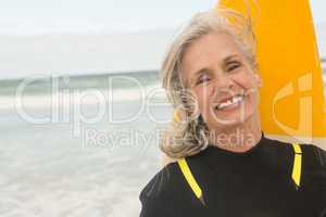 Close up of smiling woman with surfboard standing against sea